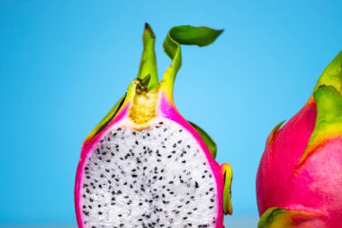 Mavi arka planda Taze Organik Ejderha Meyvesi, yaratıcı yaz yemekleri konsepti, fotokopi alanı afişi, Minimalizm Moda Yemekleri, Renkli ve Lezzetli Pitahaya