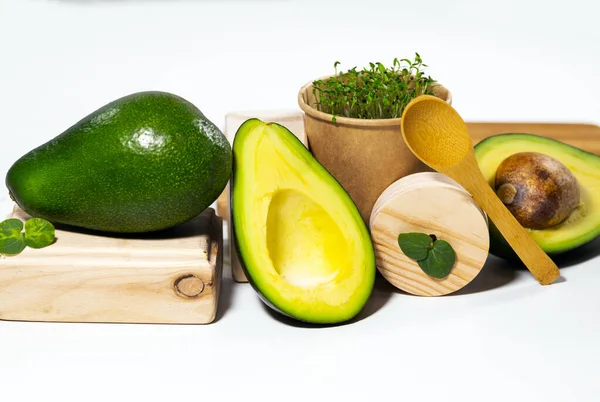 Kreativt stilleben med avokado, mikrogrön och sked på vit bakgrund med trästativ och podium. Jämvikt hälsosam mat. Balanserat näringsbegrepp. — Stockfoto