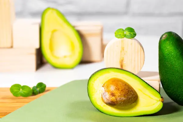 Halva mogna Avokado och mikro grön på trä pallen och står serveras på bord, vit bakgrund, Friska fet mat, Keto diet, Närbild — Stockfoto