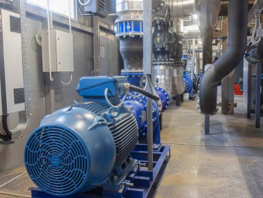 Modern bir gaz kazanının içindeki endüstriyel pompa ve boru sistemi.