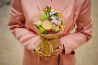 Özgün alışılmadık yenilebilir sebze ve meyve buketi kadın elinde 