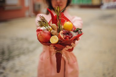 Özgün alışılmadık yenilebilir sebze ve meyve buketi kadın elinde 