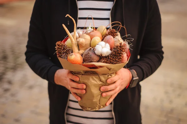 Özgün alışılmadık yenilebilir sebze ve meyve buketi adam elinde 