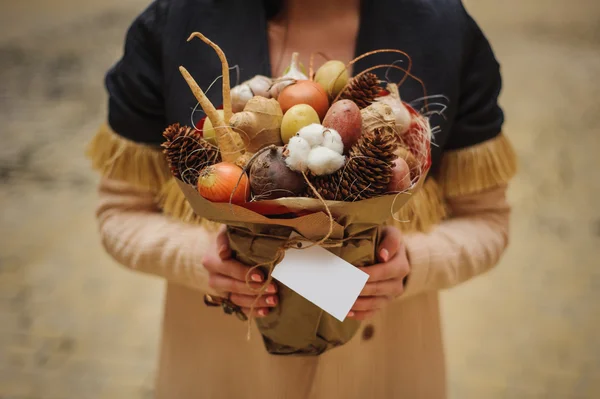 Původní neobvyklé jedlé zeleninové a ovocné kytice s kartou v rukou ženy — Stock fotografie