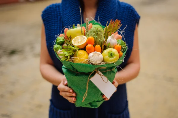 Özgün alışılmadık yenilebilir sebze ve meyve buketi kadın elinde kart ile 