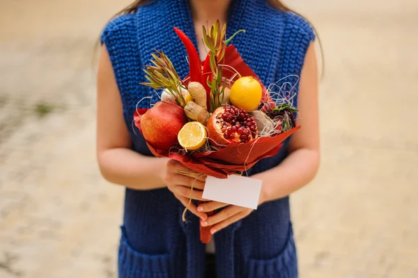 Özgün alışılmadık yenilebilir sebze ve meyve buketi kadın elinde 