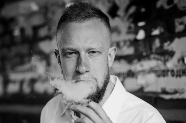 Retrato de fumar joven pelirrojo hombre con barba blanco y negro — Foto de Stock