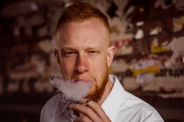 Retrato de fumar joven pelirrojo hombre con barba — Foto de Stock