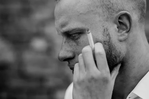 Portret van triest jonge bebaarde rood haar man met sigaret zwart-wit — Stockfoto