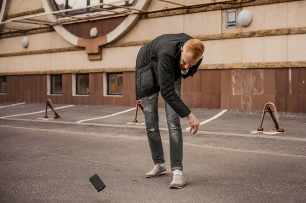 Сердитий чоловік викидає свій мобільний телефон — стокове фото