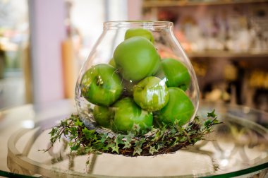 Cam vazo içinde sunulan masada yeşil elma