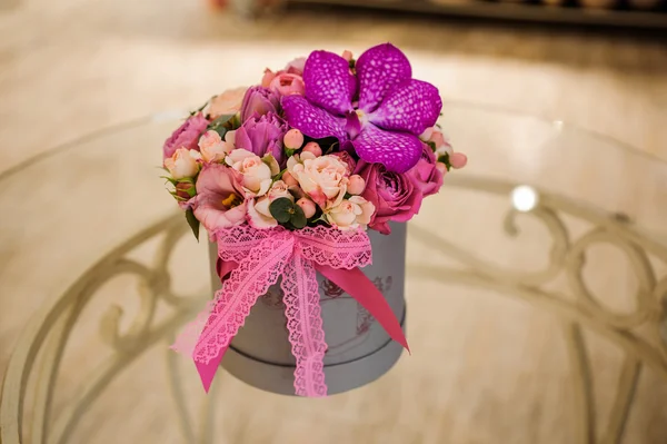 Kleiner Strauß rosa und lila Blumen in Schachtel — Stockfoto