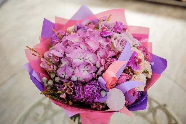 Composição buquê de flores roxas na mesa — Fotografia de Stock