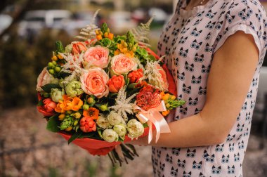 Elinde farklı turuncu çiçekler buket 