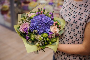 Mor çiçek buketi kompozisyon elinde 