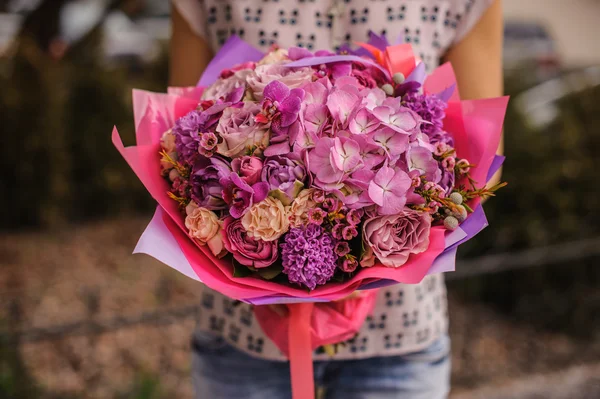 Rich bos witte en roze bloemen in handen — Stockfoto