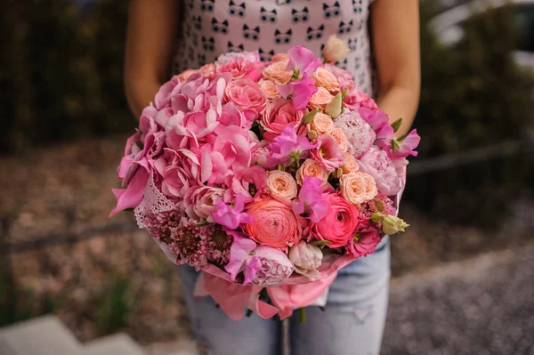 Rich bos witte en roze bloemen in handen — Stockfoto