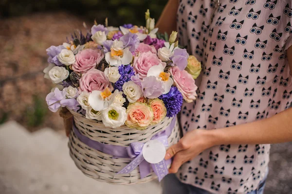 Beautiful purple  bouquet of mixed flowers in basket hold by woman — Stock Photo, Image