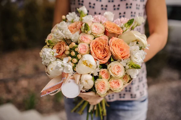 Bouquet des différentes fleurs d'orange dans les mains — Photo