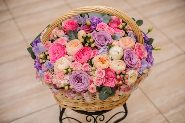 Mooi boeket van roze, paarse bloemen in mand — Stockfoto