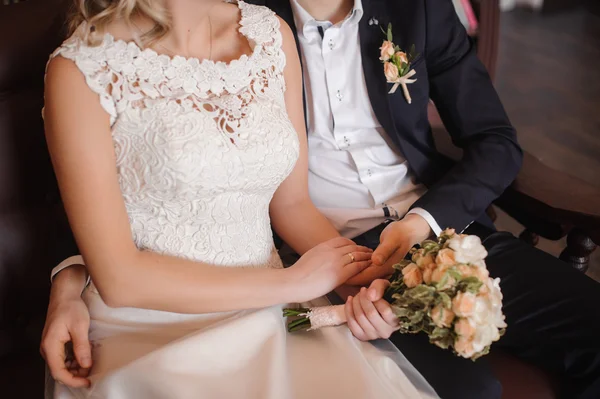 Braut und Bräutigam halten Hochzeitsstrauß — Stockfoto