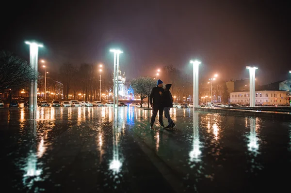 Pareja caminando por la ciudad juntos por la noche — Foto de Stock