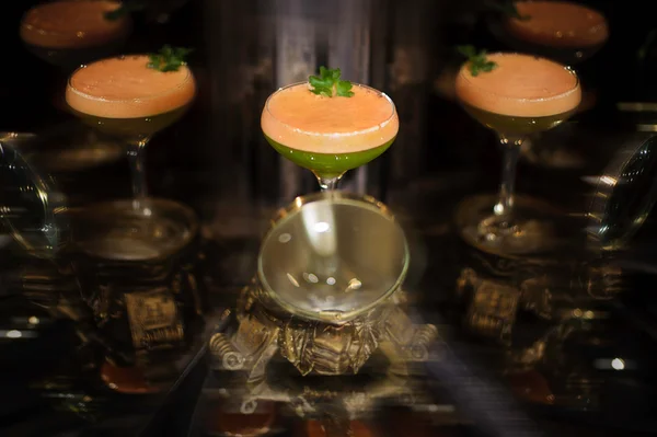Cocktail orange et vert coloré à la menthe — Photo