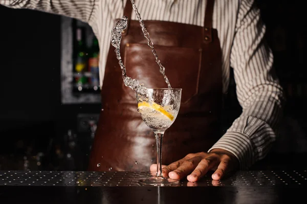 Éclaboussure dans un verre avec barman citron sur fond — Photo