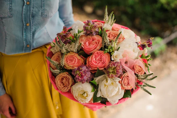 Flicka håller bukett av olika blandade orange-vita blommor — Stockfoto