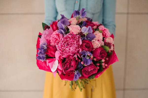 Girl holding bouquet of a mixed pink and purple flowers — Stock Photo, Image