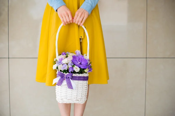 Niña sosteniendo hermoso ramo púrpura de flores mixtas en cesta — Foto de Stock