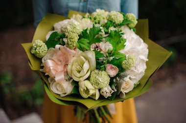 bir buket beyaz çiçek tutan kız