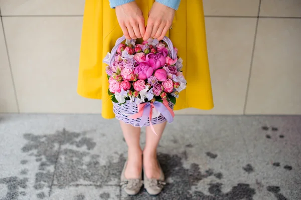 Menina segurando lindo buquê rosa de flores mistas na cesta — Fotografia de Stock