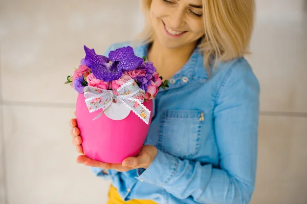 Menina segurando lindo buquê rosa de flores misturadas em vaso — Fotografia de Stock