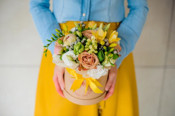 Menina segurando bonito buquê de flores mistura em caixa redonda com tampa — Fotografia de Stock