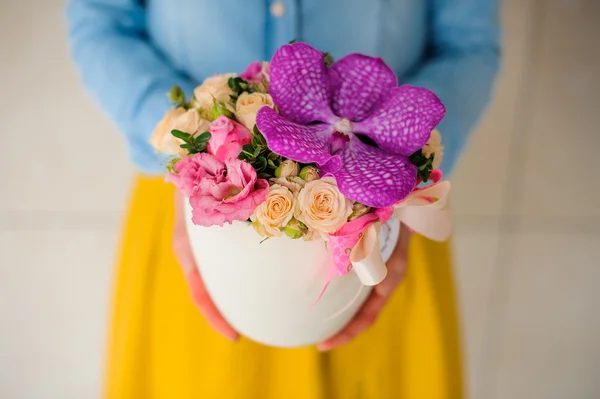 Dziewczynka gospodarstwa piękny różowy bukiet z mieszanych kwiatów w wazonie — Zdjęcie stockowe