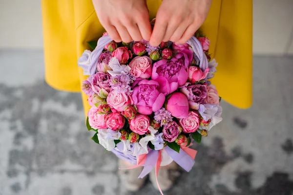 Menina segurando lindo buquê rosa de flores mistas na cesta — Fotografia de Stock