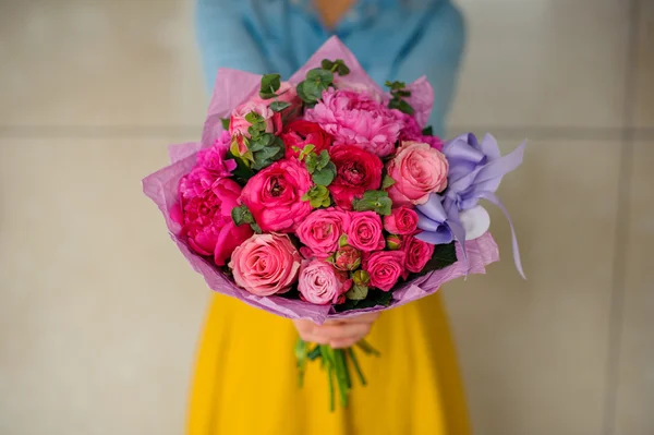 Menina segurando buquê de uma mistura de flores rosa e roxo — Fotografia de Stock