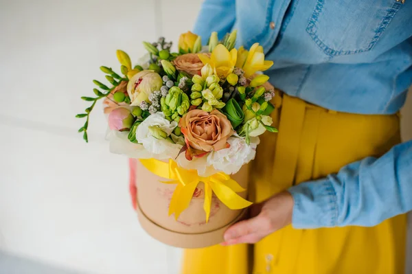 Meisje met mooie mix bloemboeket in ronde doos met deksel — Stockfoto