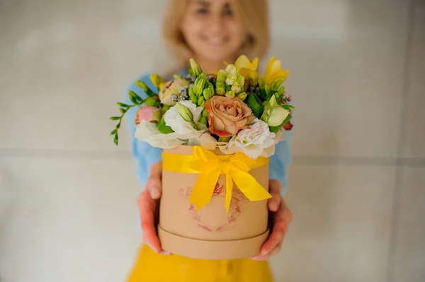 Menina segurando bonito buquê de flores mistura em caixa redonda com tampa — Fotografia de Stock