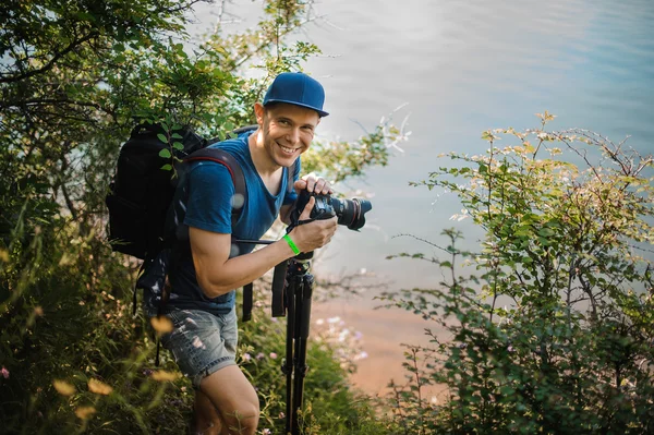 Jeune homme tenant un appareil photo numérique — Photo