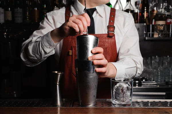 El camarero está revolviendo cócteles en el mostrador del bar — Foto de Stock