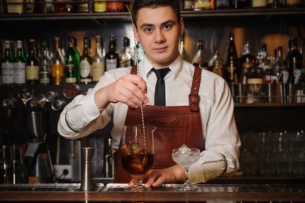Bartender is stirring cocktails on the bar counter — Stock Photo, Image