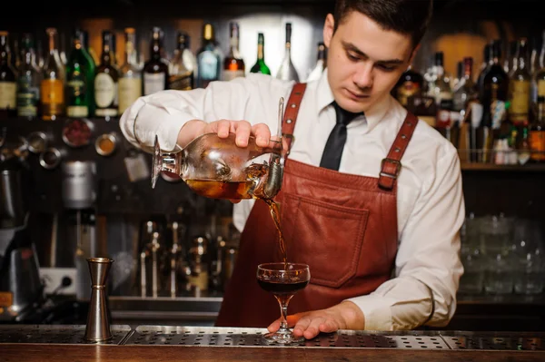 Barkeeper gießt frischen Cocktail in schickes Glas — Stockfoto