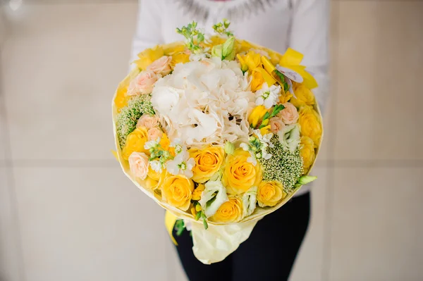 Belo buquê de flores amarelas em mãos a menina — Fotografia de Stock