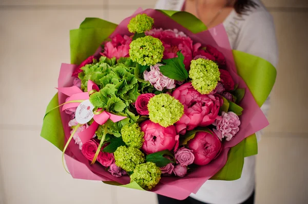 Fille tenant bouquet de fleurs roses et vertes — Photo