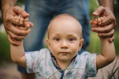 Bebek çocuk yürümeyi öğrenme ve ilk adımlarını tutuşup bir baba yapma.
