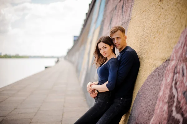 Casal abraçando ao lado da parede de grafite — Fotografia de Stock