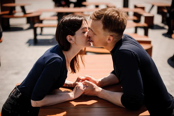 Jovem e atraente casal de mãos dadas prestes a beijar sobre a mesa no restaurante — Fotografia de Stock