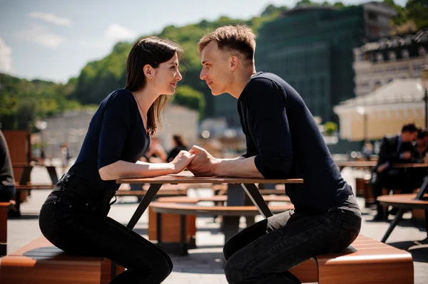 Jong en aantrekkelijk paar hand in hand gaan kus boven tafel in restaurant — Stockfoto